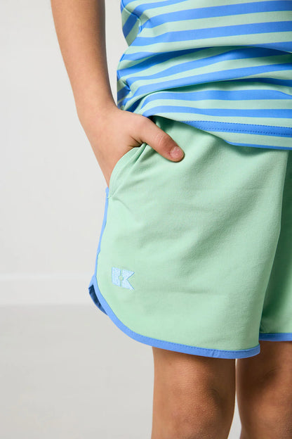 Light green shorts with blue trim worn by a person on a plain background