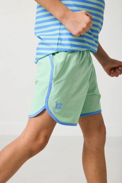 Person wearing green shorts with blue trim and a matching striped shirt on a light gray background
