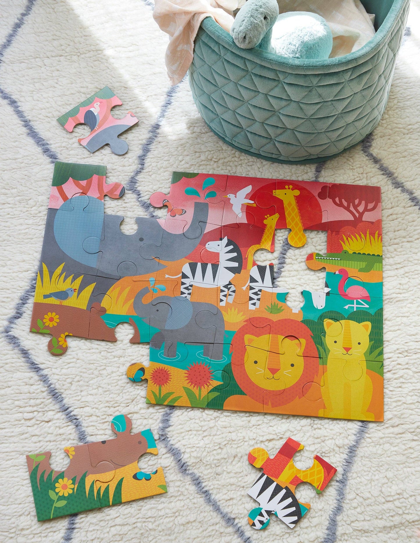 Children's animal-themed puzzle on a patterned rug with a teal basket in the background.