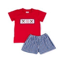 Red t-shirt with white logo and blue checkered shorts on a white background