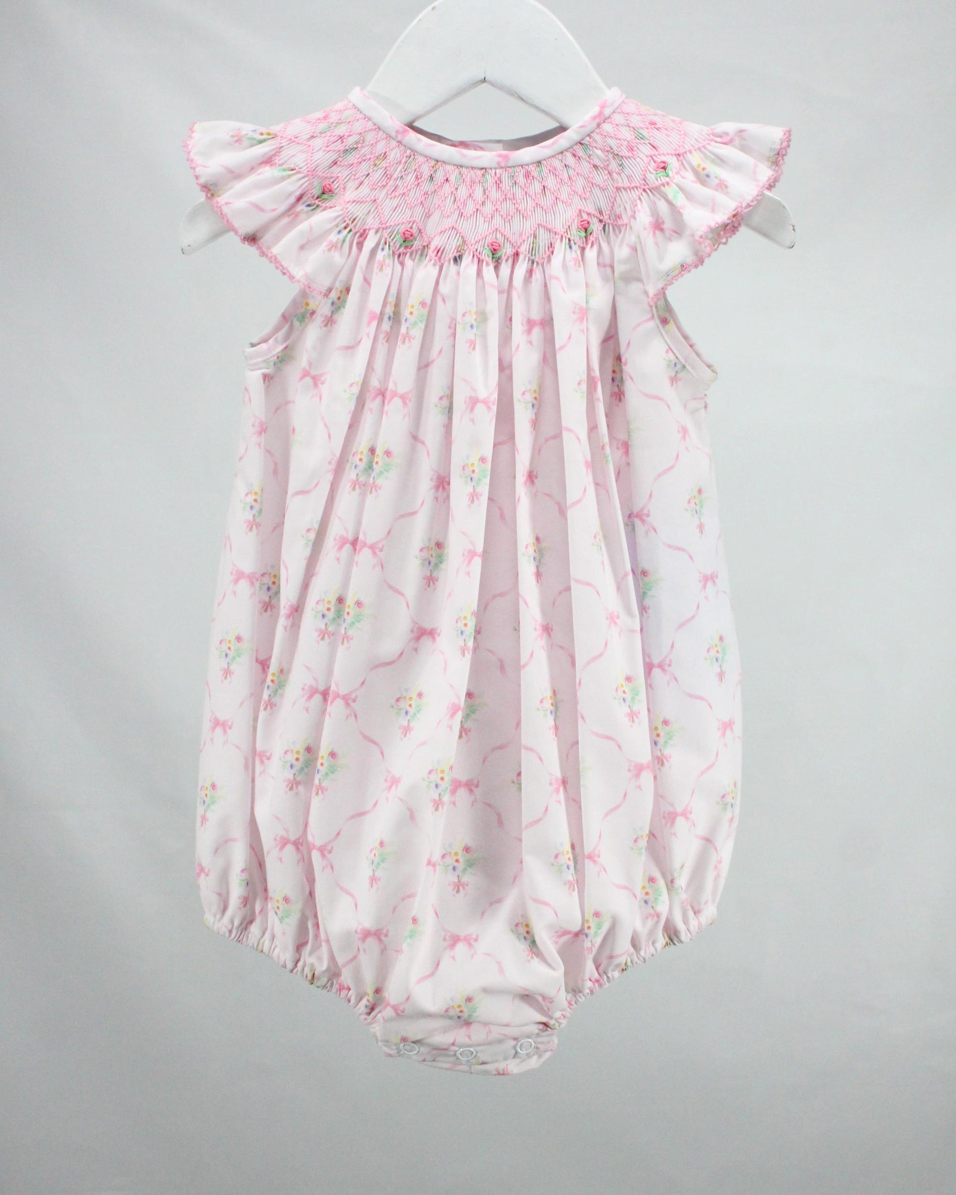 Pink floral baby romper on a gray background