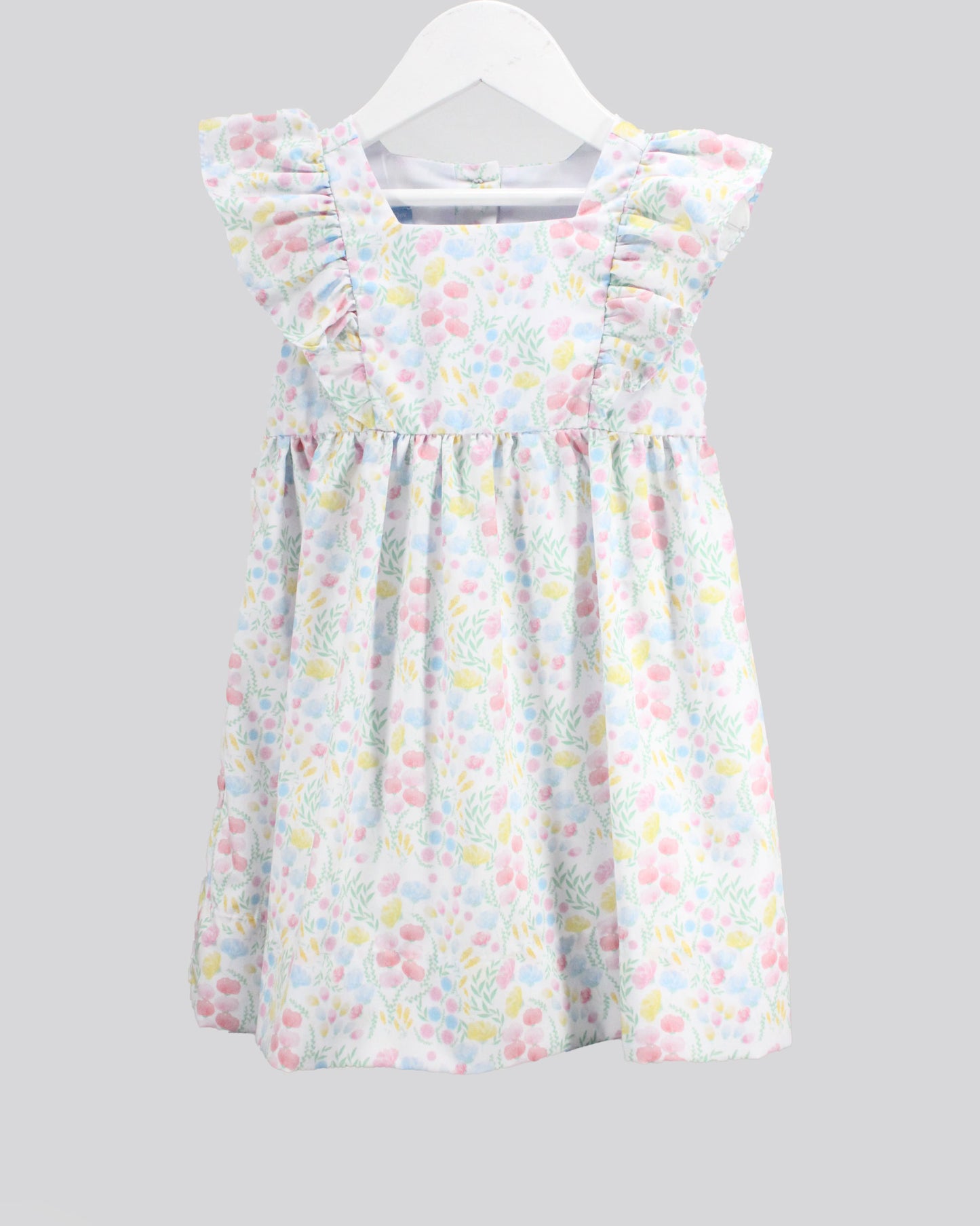 Children's dress with a floral pattern on a white hanger against a gray background