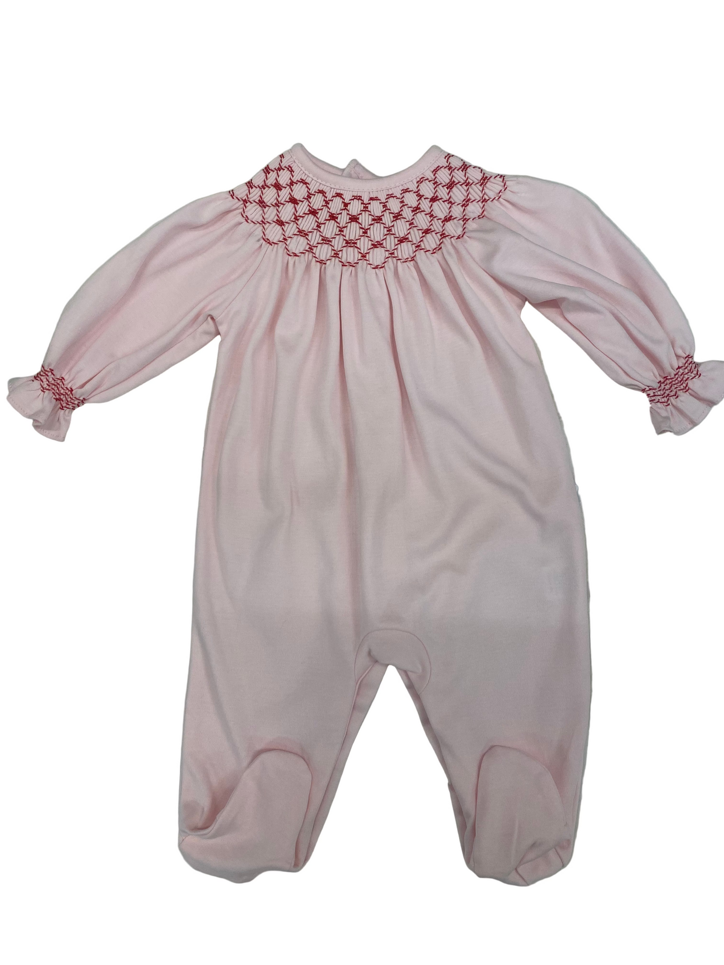 Pink baby onesie with red smocking on a light marble floor