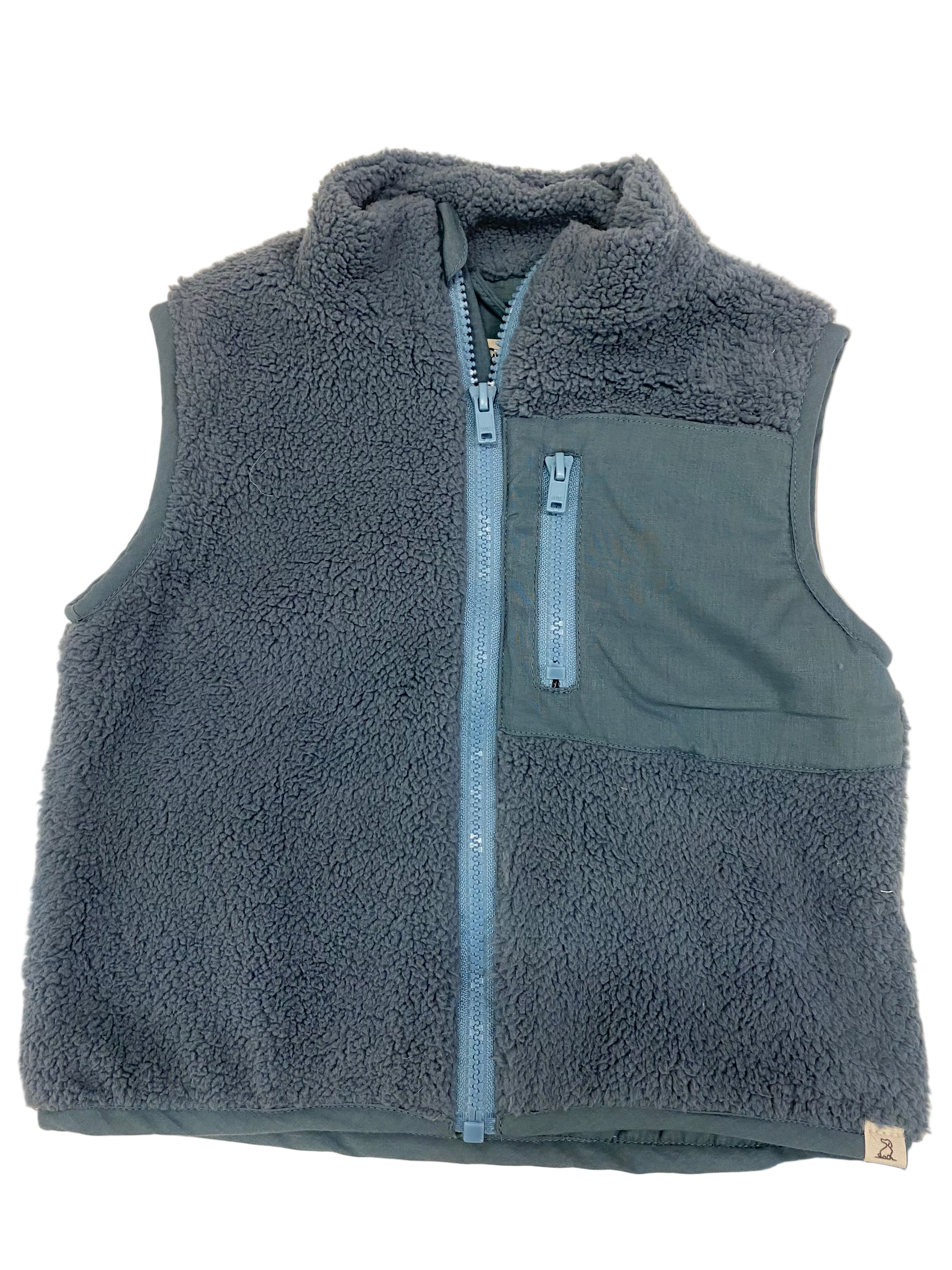 Gray fleece vest with a zipper on a light brown surface