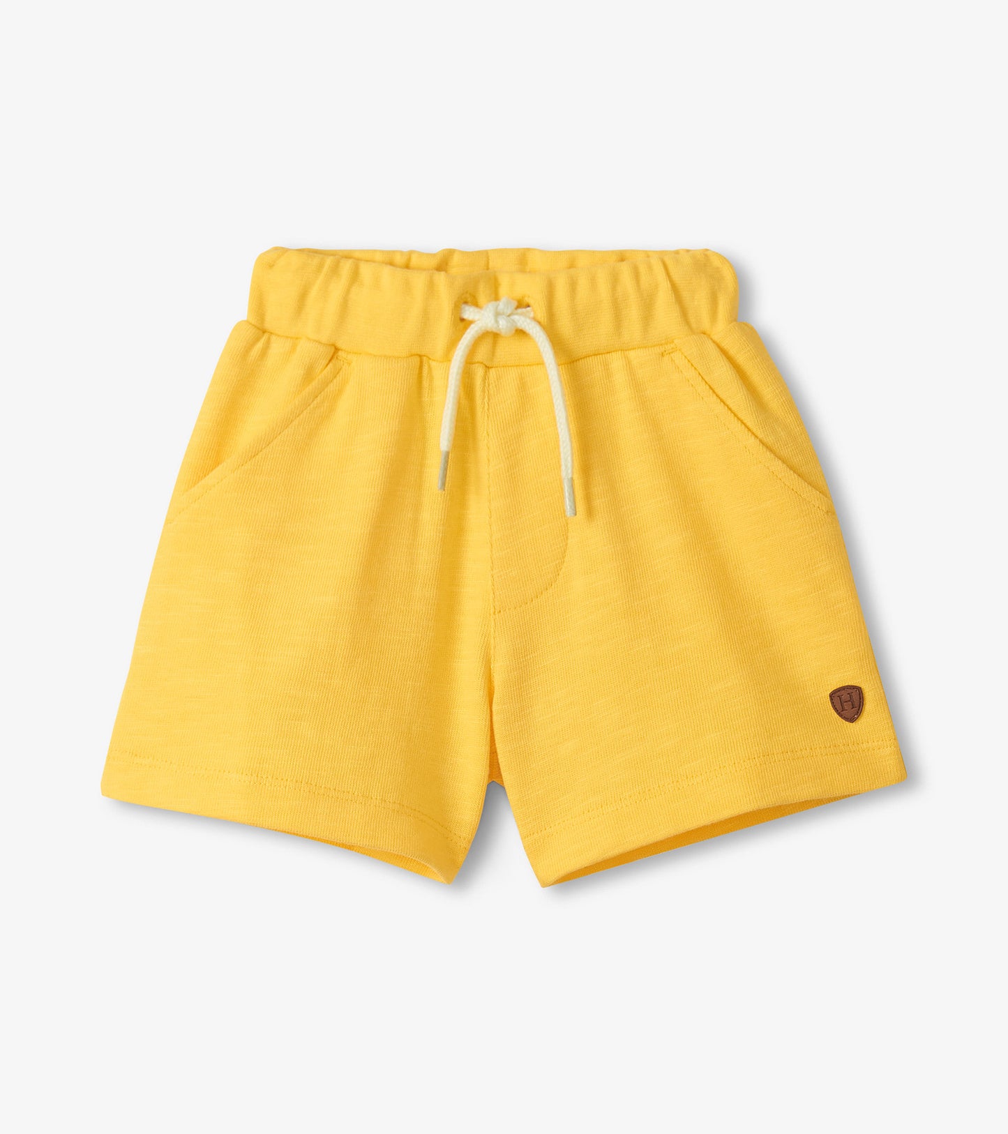 Yellow shorts with a small logo on a light gray background