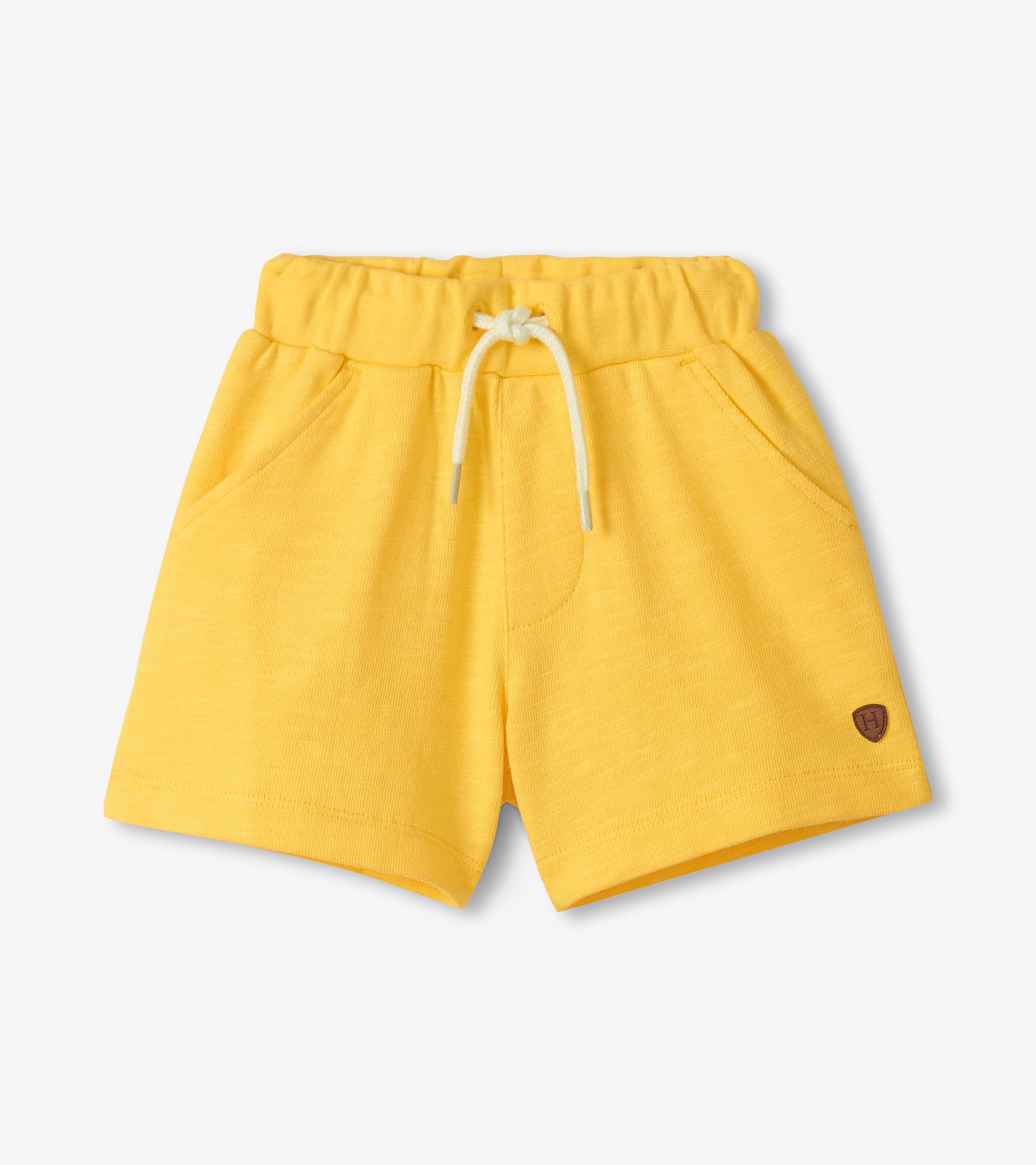 Yellow shorts with a small logo on a light gray background