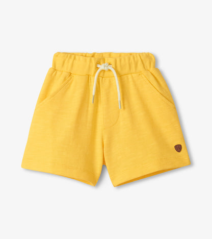 Yellow shorts with a small logo on a light gray background