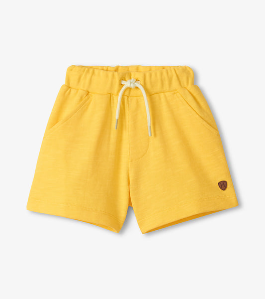 Yellow shorts with a small logo on a light gray background